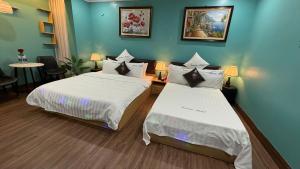 two beds in a room with blue walls at Dream Hotel in Hanoi +40 photos