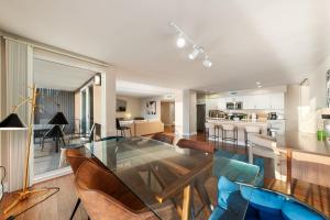 Un comedor y una cocina con una mesa de cristal y sillas. en Azure Marina Luxe - Waterfront with Sunset Views, en Los Ángeles