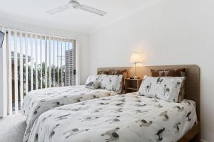 a white bedroom with two beds and a window at 1-68 Woodburn Street in Evans Head