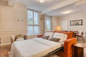 Splendid 10PAX apartment in the center of Paris في باريس: غرفة نوم بها سرير وكرسي وطاولة +38 صورة