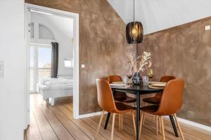 a dining room with a table and chairs and a mirror at LK1942-Lokken-Klithavevej-3-1 in Løkken