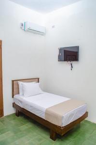 a bedroom with a bed with a tv on the wall at Puertas de la Bahía in Santa Marta