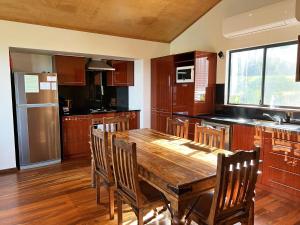 a kitchen with a wooden table and wooden chairs at Serendeva: Stunning views, private & EV charger in Denmark +15 photos