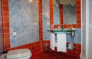 a bathroom with a toilet, sink, and tub at Hotel Monti Di Mola in Porto Cervo