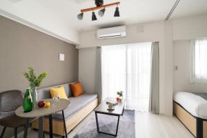 a living room with a couch and a table at Haven Shibaura in Wada +37 photos
