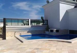 a swimming pool on the side of a house at Prainha Arraial do Cabo Loft in Arraial do Cabo