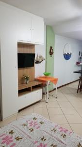 a kitchen with a tv and a table in a room at Prainha Arraial do Cabo Loft in Arraial do Cabo