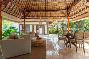 a living room with a couch and chairs and a table at Three Bedrooms Elegant Home The White Door Villa in Sanur
