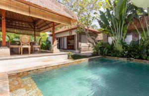 a swimming pool in front of a house at Three Bedrooms Elegant Home The White Door Villa in Sanur