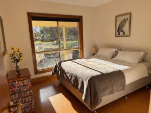 a bedroom with a large bed and a window at Barossa Garden Homestay in Williamstown