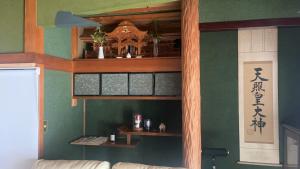 a living room with green walls and wooden shelves at みなと館 華 in Sukumo +29 photos