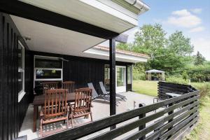 a patio with a table and chairs on a house at 84132-Ebeltoft-Laerkevej-80 in Ebeltoft