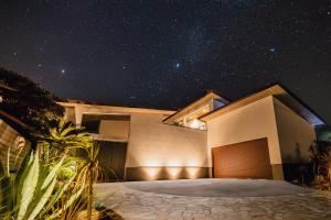 Una casa de noche con un cielo estrellado en ロマン詰まる大人のプレミアムヴィラ,プール,ゴルフ,ガレージ,BBQ ---Surf up---, en Ichinomiya