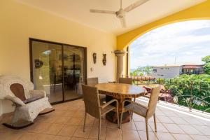 a patio with a wooden table and chairs on a balcony at Sunrise 7 - 2 Bedroom, Ocean View Condo in Tamarindo