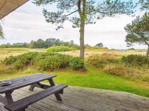 einem hölzernen Picknicktisch auf einer Holzterrasse in der Unterkunft 6 person holiday home in Glesborg-By Traum in Bønnerup