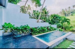 a swimming pool with a chair next to a house at Villa Matahari Ubud in Gianyar
