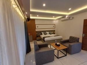 a bedroom with a bed and a couch and a table at East West Beach Resorts in Varkala +82 photos