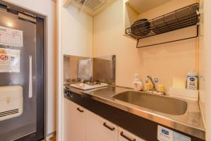 a small kitchen with a sink and a refrigerator at Wajiro Good Place House in Fukuoka