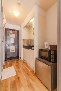 a kitchen with a microwave on a counter in a room at Wajiro Good Place House in Fukuoka