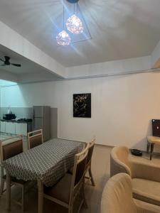a dining room with a table and chairs and a kitchen at Sampoisgt Homestay - 3 Bedrooms, Free 4 Private Parking, Extra mattresses available in Kajang
