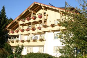 un gran edificio blanco con flores en los balcones en Haus Vierjahreszeiten, en Bodenmais