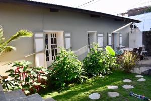 a house with a yard with plants in front of it at Maisonette de Charme à Terre Sainte in Saint-Pierre