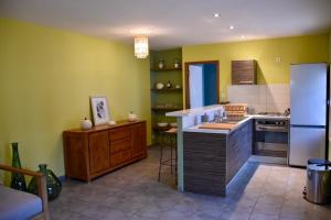 a kitchen with yellow walls and a white refrigerator at Maisonette de Charme à Terre Sainte in Saint-Pierre