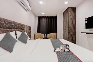 a bedroom with a bed with a white bedspread at Super Townhouse Roadway Inn in New Delhi