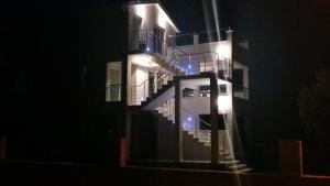 - un bâtiment éclairé avec des escaliers la nuit dans l'établissement Villa Vinko, à Rogoznica