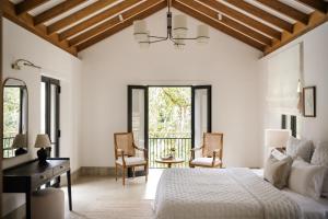 a bedroom with a bed and a desk and chairs at Sa House - Talpe in Galle