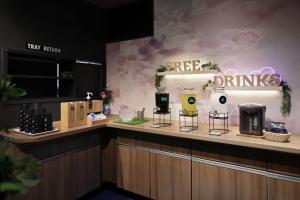 a coffee bar with a free drinks sign on the wall at Nipponbashi Crystal Hotel in Osaka
