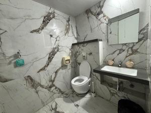 baño de mármol con aseo y lavamanos en Vibrant Vision Near Airport with Coffee Maker & Wifi, en Pune 48 fotos más