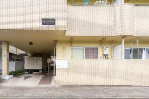 an entrance to a building with a brick wall at Ijiri Good Place House in Fukuoka