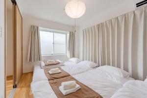 a bedroom with two beds with towels on them at Ijiri Good Place House in Fukuoka