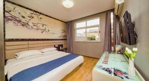 Postel nebo postele na pokoji v ubytování Kunlun Leju Business Hotel Kaifeng Gulou
