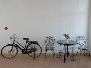a bike and a table and chairs next to a wall at The Passion Hotel in Chiang Mai