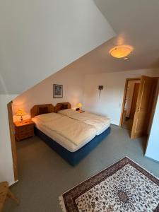 a bedroom with a large bed with two lamps on it at Ferienwohnungen Landhaus Stottmert in Herscheid