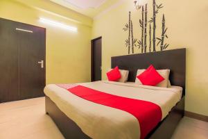 a bedroom with a large bed with red pillows at Hotel O Raghukul in Jaipur