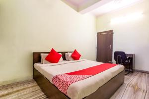 a bedroom with a large bed with red pillows at Hotel O Raghukul in Jaipur