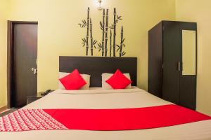 a bedroom with a large bed with red pillows at Hotel O Raghukul in Jaipur
