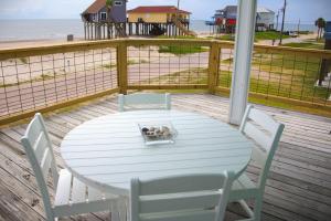 a small dog in a bowl on a white table on a porch at The Pelican Pass in Freeport