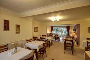 een eetkamer met tafels en stoelen. bij Churston Way Lodge Guest House in Brixham