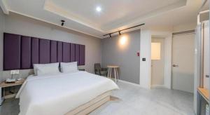 a bedroom with a large white bed and a desk at Best In City Hotel in Daejeon +73 photos