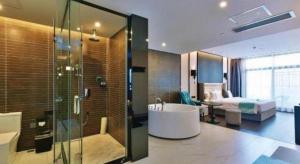 ein Bad mit einer Badewanne und ein Schlafzimmer in der Unterkunft Xana Hotelle Chengdou Xindu Sanhechang Metro Station in Chengdu + 71 Fotos