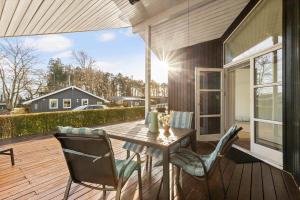 a patio with a table and chairs on a deck at 8106-Ronde-Lindeparken-10 in Rønde