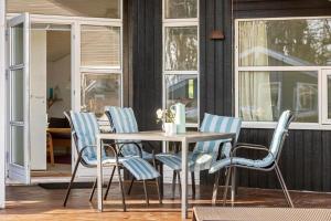 a wooden table and chairs on a patio at 8106-Ronde-Lindeparken-10 in Rønde +19 photos