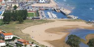 Una vista de una playa con barcos en el agua. en El Bodegon de Luis, en Hinojedo