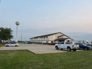 a parking lot with cars parked in front of a building at Super 8 by Wyndham Mendota I-39 in Mendota