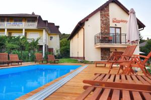 a villa with a swimming pool and a house at Barackvirág Apartmanház in Tihany