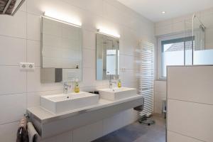 a white bathroom with two sinks and a mirror at Ferienhaus Kiliani in Bernau im Schwarzwald